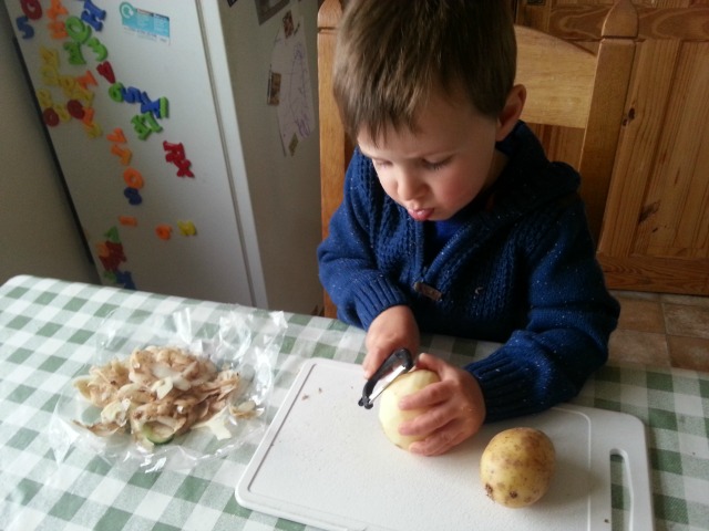 preschooler peeling potatoes