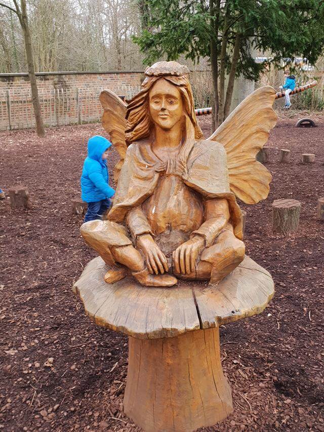 tinkerbell fairy sitting on a mushroom sculpture