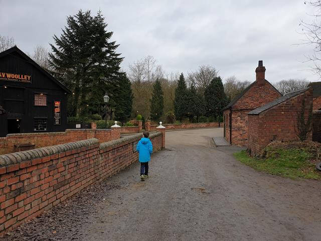 boy walking in the distance by a wall