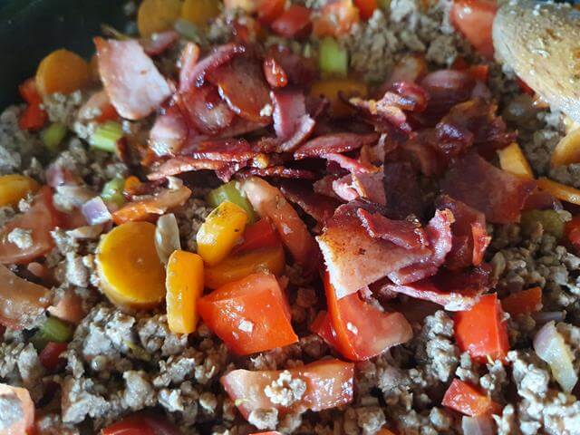 adding veg and bacon to mince