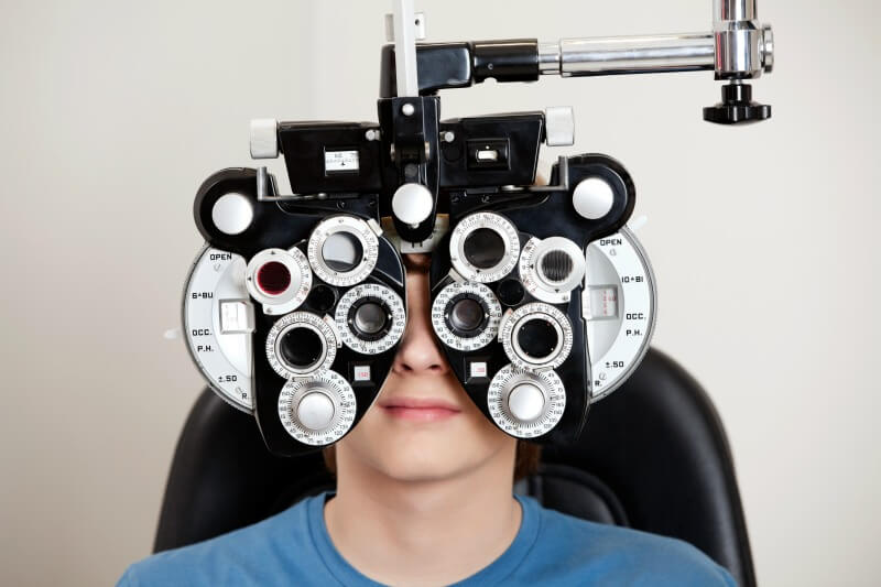 boy in eye test with prescription glasses machine