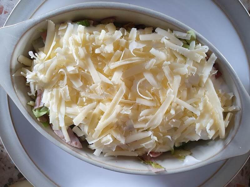 grated cheddar cheese atop a cabbage and ham casserole