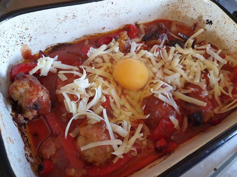 sausage and tomato bake topped with cheese and egg