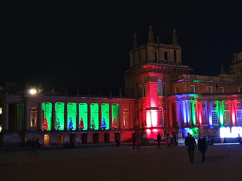 distance view of red and green lit up blenheim palace frontage