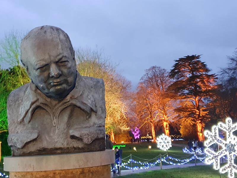 large stone winston churchill bust in front of giant lit up snowflakes