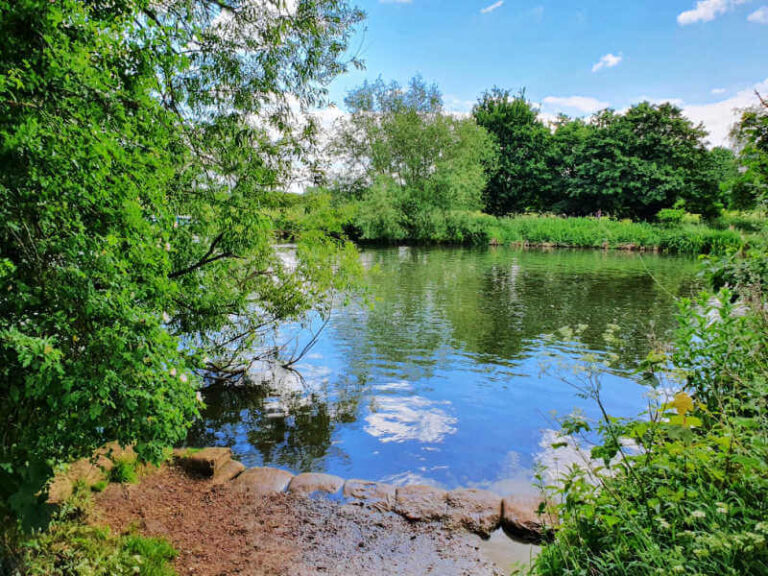 river thames with blue sky and clouds reflected