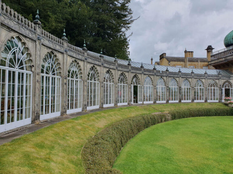 curve of an orangery of windows with curve of grass in front