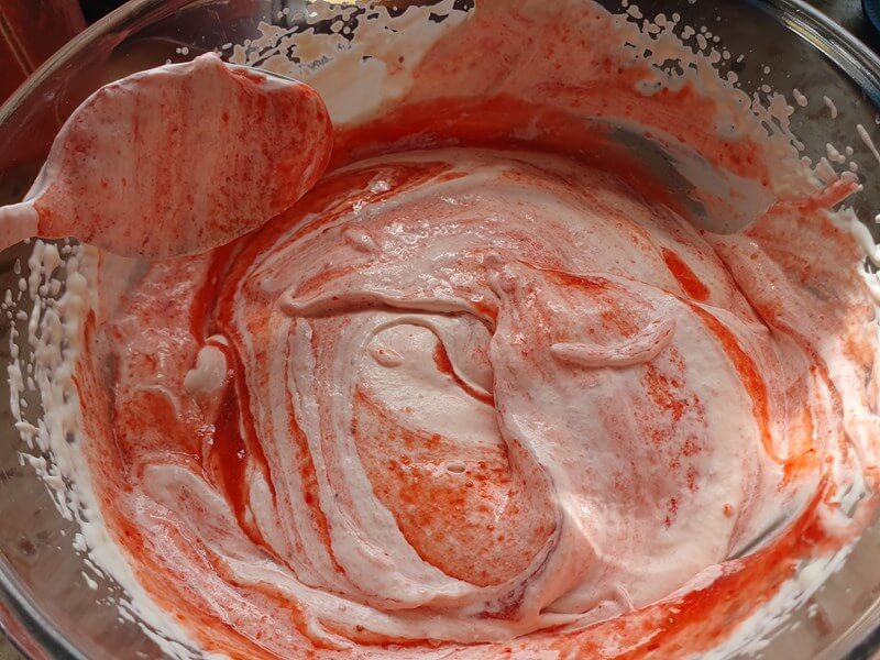 mixing in strawbrry puree to whippped cream