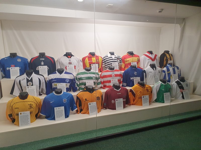 3 rows of football jerseys of Scottish club teams on display on half mannequin bodies
