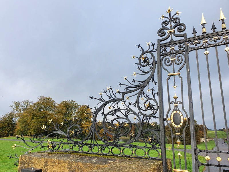 ironwork gate with gold accent overlooking trees