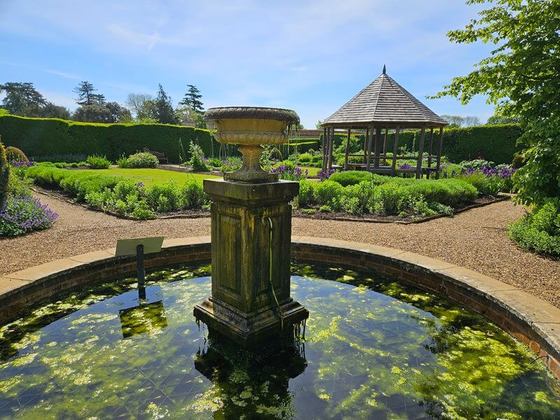 pond with water fountain looking across with gazebo in the background