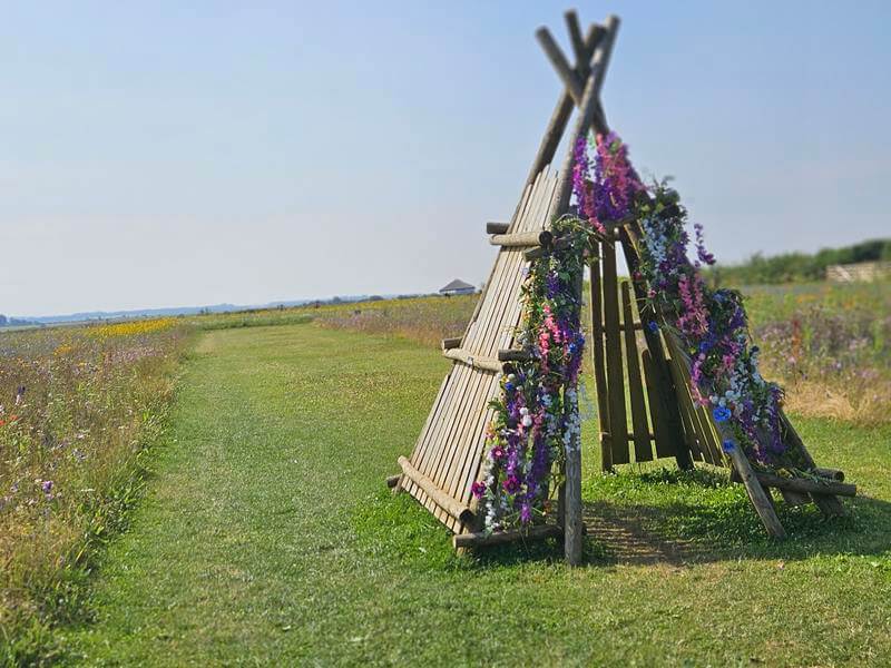 wooden floral decorated teepee structure in the flower field