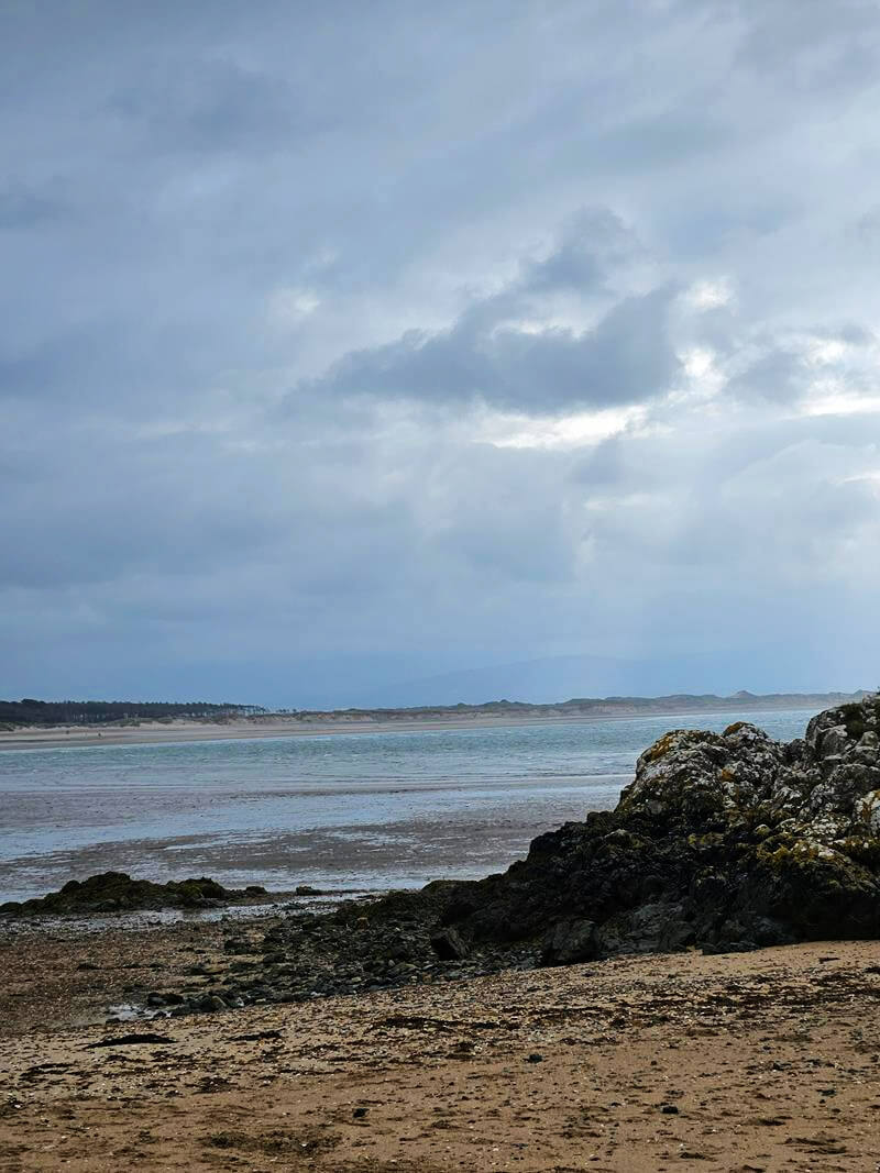 rocks and beach behind newborough beach