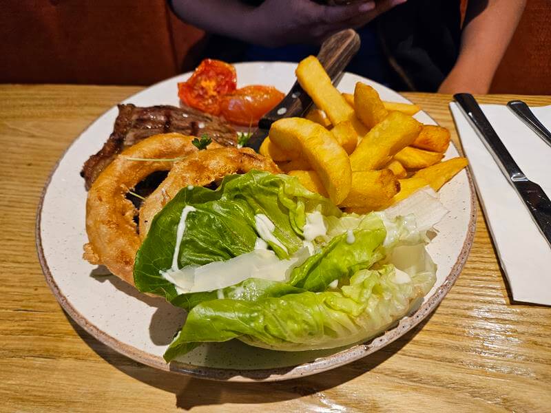 steak onion rings chips tomatoes and lettuce