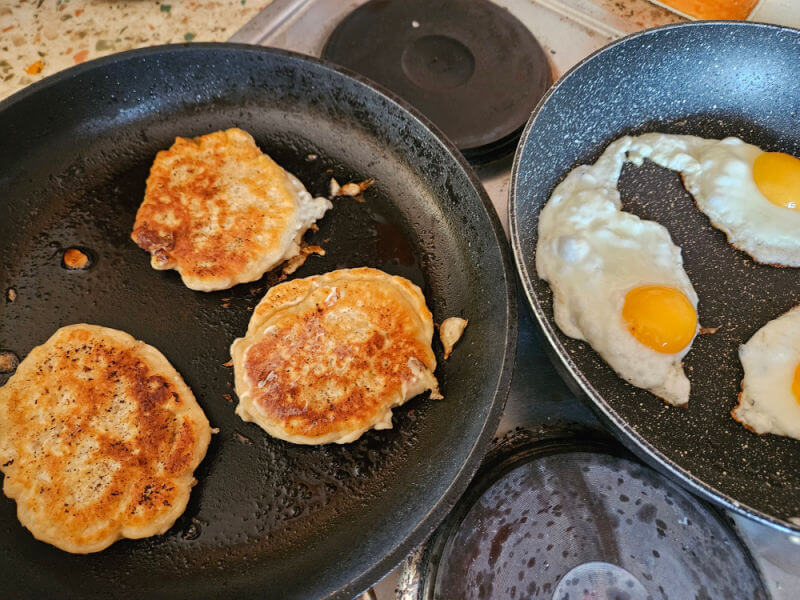 bacon cakes in one pan, eggs in another