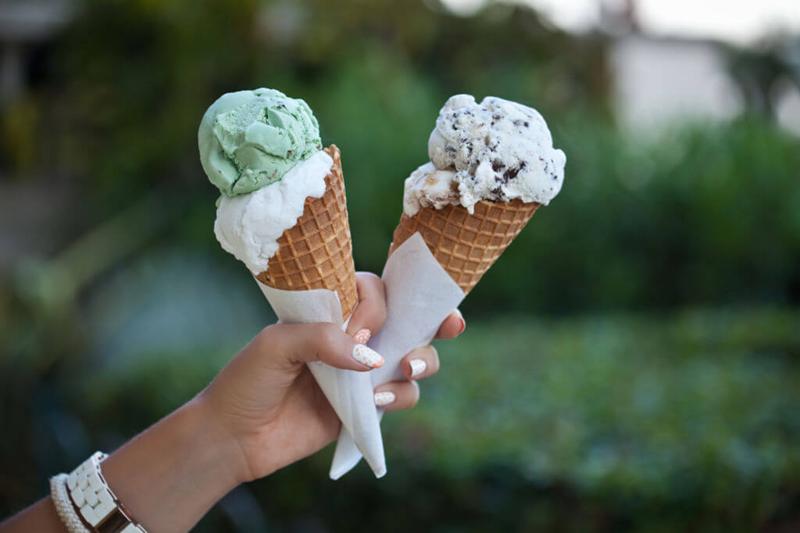 hand holding up 2 ice cream cones