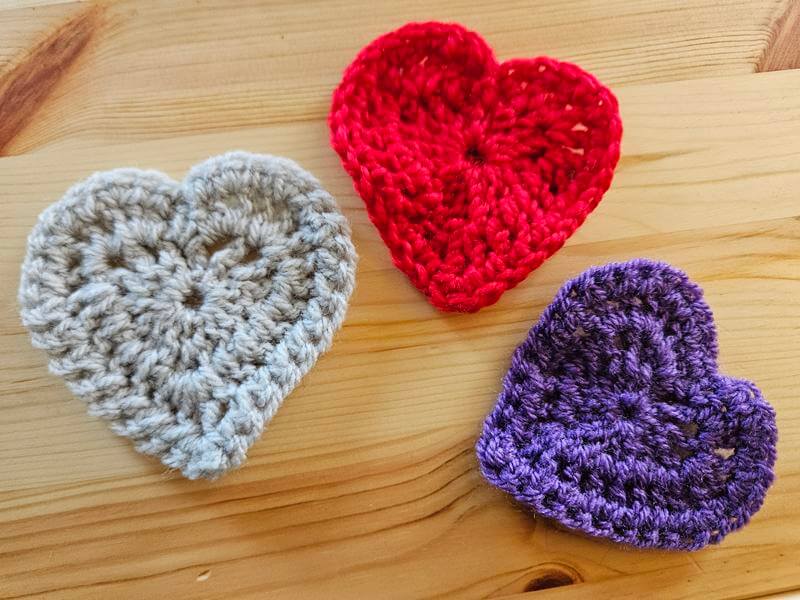 3 Completed crochet hearts in different colours