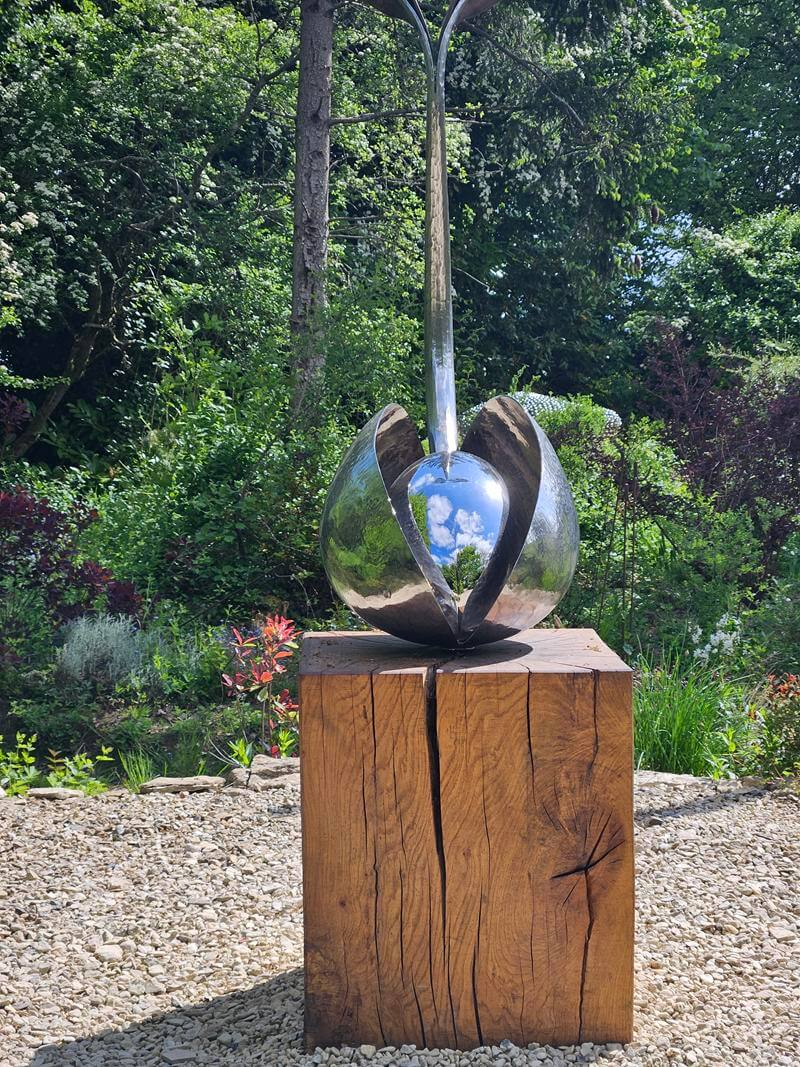 emerging metal sculpture with reflection in