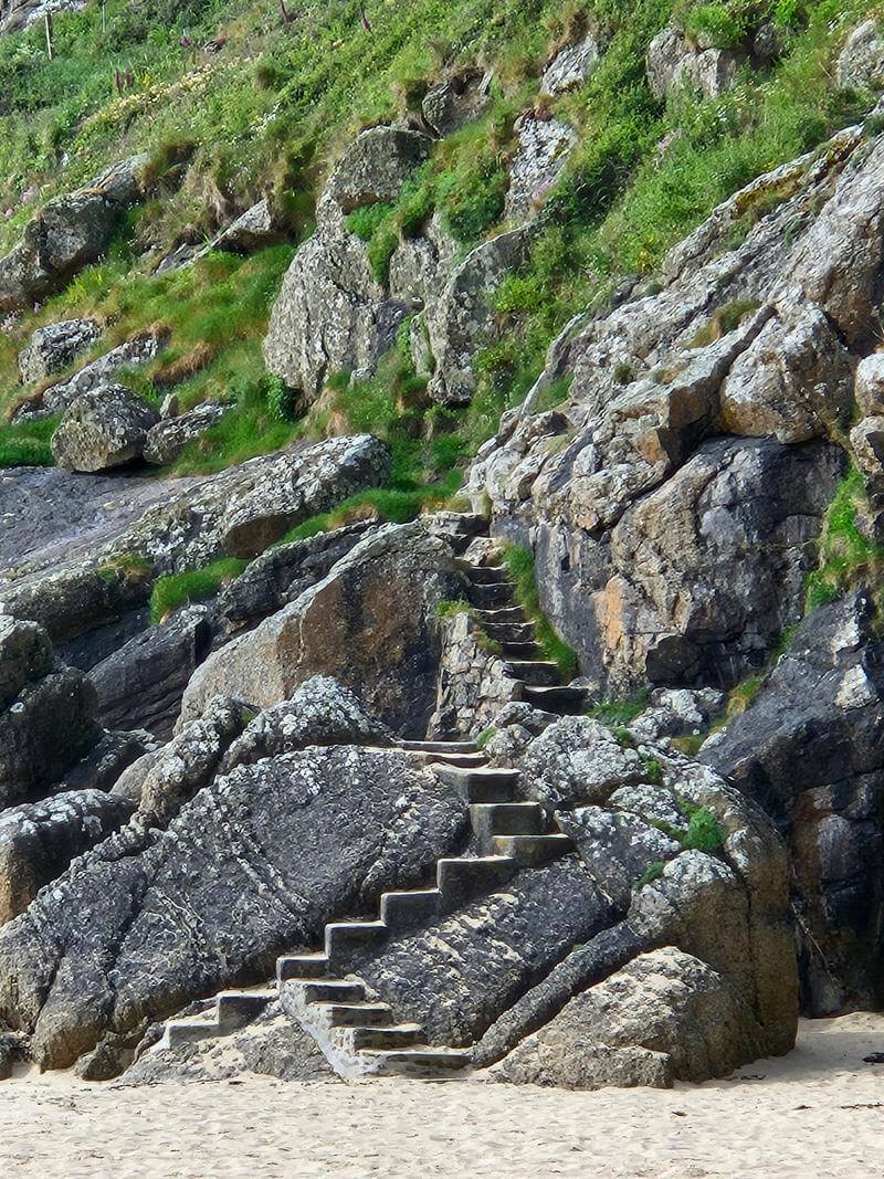 close up of stairs up the cliffs at porthcurno beach