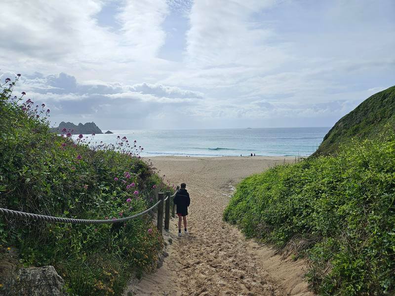 walking down onto the sand at porthcurno beach